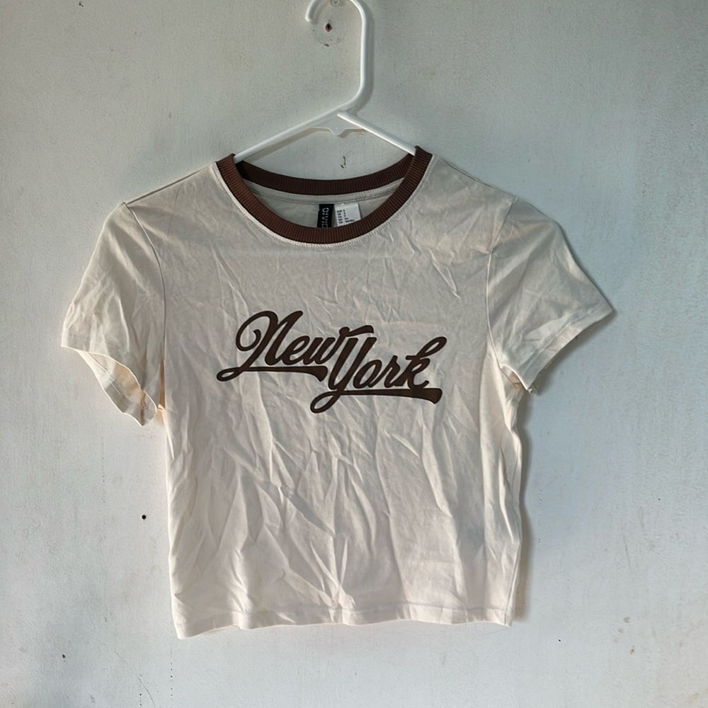 H&M baby t, cream with brown writing and is the divided brand.